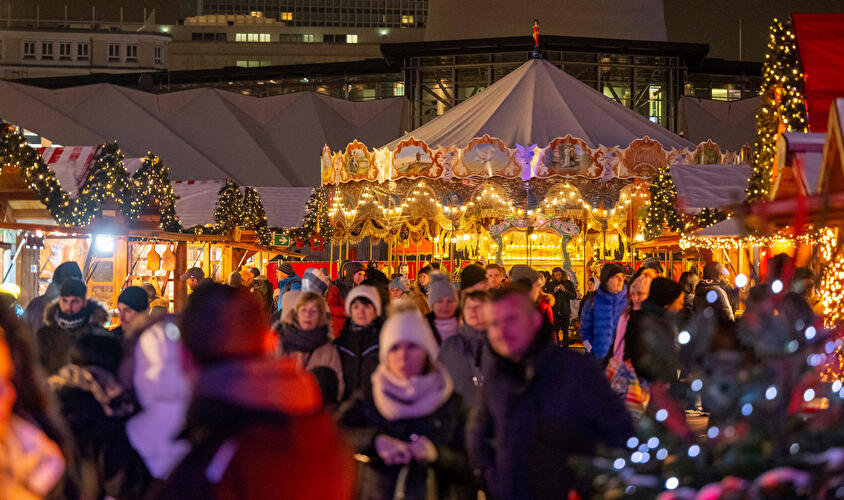 Enjoy the magical atmosphere of Berlin Christmas Market with its sparkling carousel, holiday market stalls, and joyful crowds. This enchanting night scene captures twinkling lights, family fun, and the vibrant spirit in the heart of Berlin’s Rotes Rathaus Christmas market