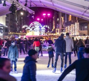 Families and visitors skating at the festive ice rink in Place de Brouckère, Brussels Christmas Market in Belgium, surrounded by sparkling lights, cheerful crowds, and magical winter decorations.