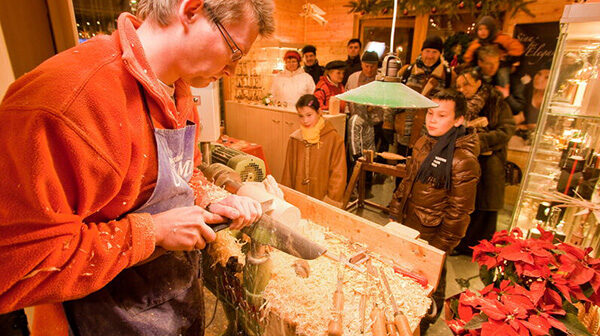 Top 10 Kindvriendelijke Kerstmarkten in Duitsland 43 Discover authentic craftsmanship at Dresden Striezelmarkt with a live woodcraft demonstration. This warm, festive scene captures skilled artisans at work, curious visitors, and the cozy holiday atmosphere at one of Germany’s oldest Christmas markets.
