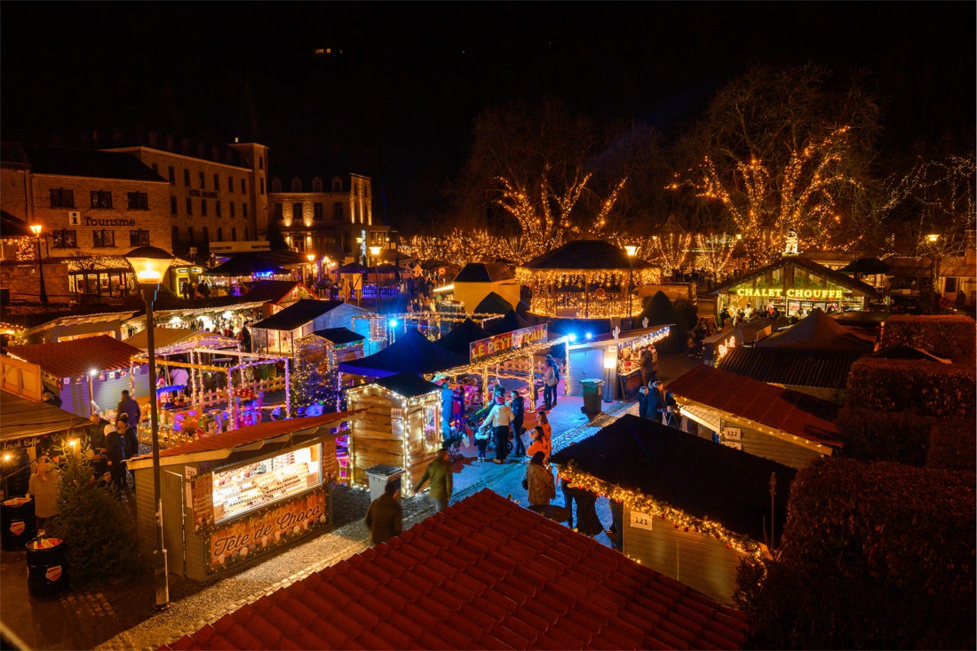 Top 10 Kindvriendelijke Kerstmarkten in Belgiƫ 105 Aerial view of Durbuy Christmas Market in Belgium, featuring glowing wooden chalets, festive lights, holiday crowds, and rustic charm in the illuminated center of the smallest city in the world.