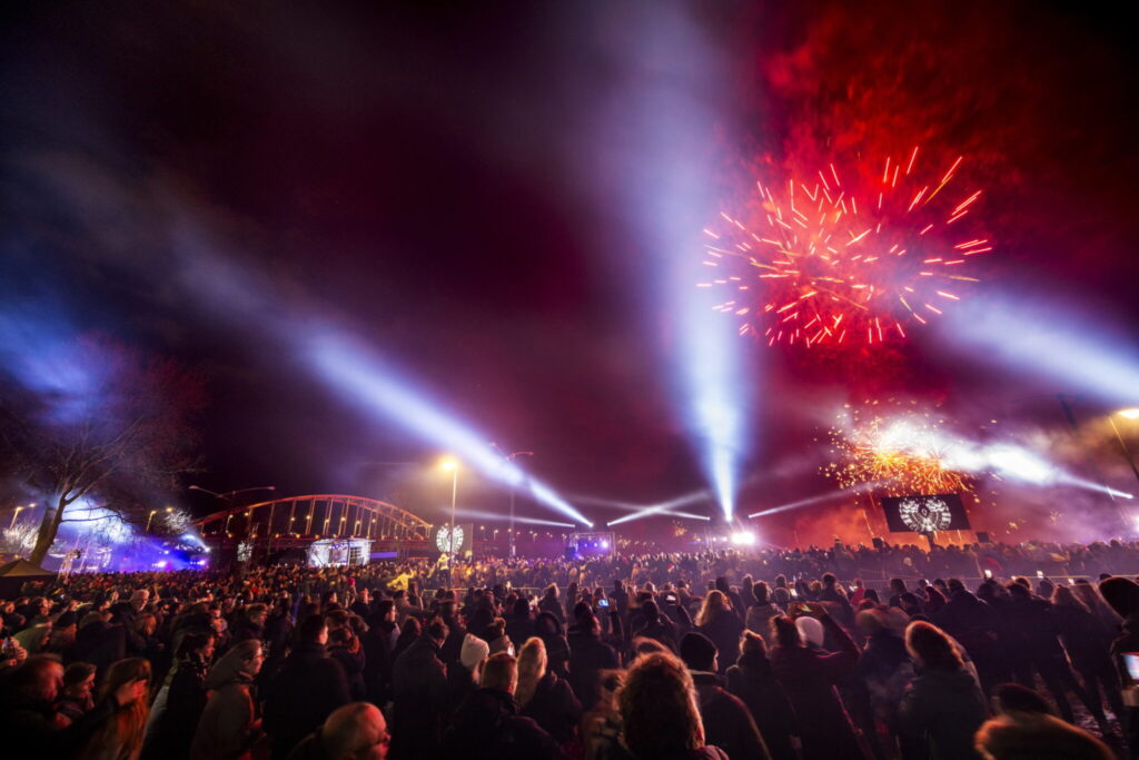 Spectacular fireworks display and bright festival lights fill the night sky over Arnhem’s John Frost Bridge during Winter in Arnhem. Large crowds enjoy family-friendly celebrations, music, and holiday atmosphere at this popular Christmas event in the Netherlands.