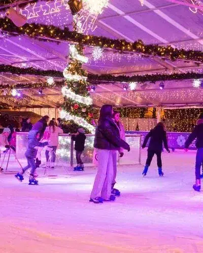 Top 10 Kindvriendelijke Kerstmarkten in Belgiƫ 95 People ice skating beneath sparkling holiday lights and garlands at the indoor rink, with a decorated Christmas tree centerpiece, at Hasselt Christmas Market in Belgium's Winterland festival.