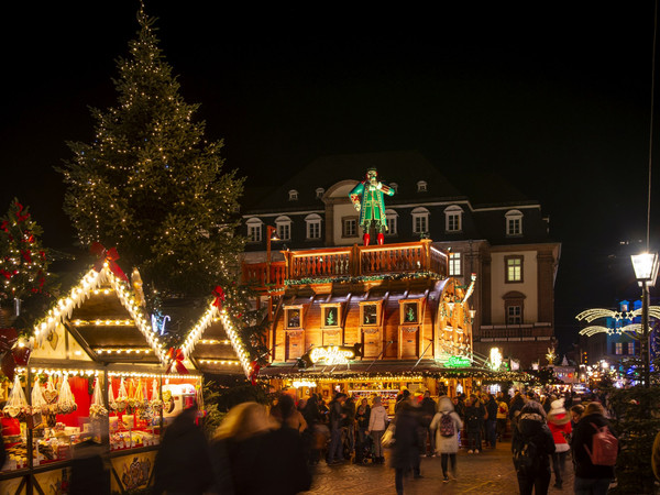 Explore the enchanting Heidelberg Christmas Market with its cozy wooden stalls, glowing Christmas tree, and vibrant holiday crowds. This atmospheric night scene captures festive lights, holiday treats, and joyful winter celebrations in the heart of Heidelberg’s old town
