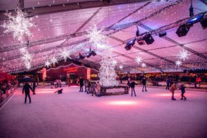 Top 10 Kindvriendelijke Kerstmarkten in Belgiƫ 91 Magical indoor ice skating rink at Liege Christmas Market in Belgium, decorated with glowing snowflake lights, a luminous tree centerpiece, and families enjoying festive holiday fun.