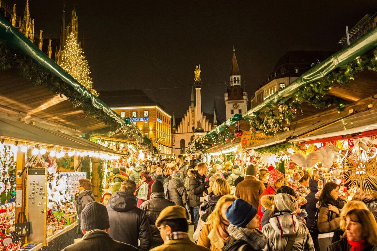 Discover the vibrant Munich Christmas Market with rows of beautifully decorated stalls, sparkling lights, and cheerful holiday shoppers. This bustling night scene captures traditional crafts, festive treats, and the magical atmosphere in Munich’s historic city center.