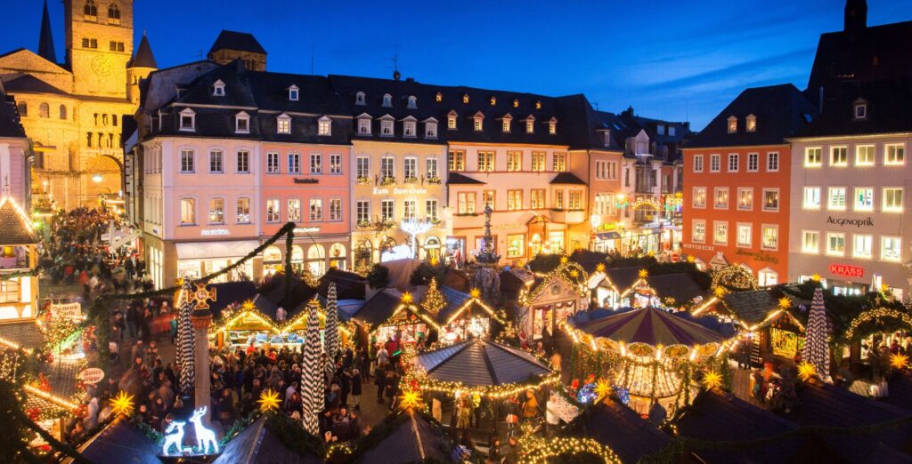 Top 10 Kindvriendelijke Kerstmarkten in Duitsland 57 Discover the enchanting Trier Christmas Market with its glowing holiday stalls, charming carousel, and majestic backdrop of Trier Cathedral. This magical evening scene captures twinkling lights, local traditions, and the festive spirit in Germany’s oldest city.